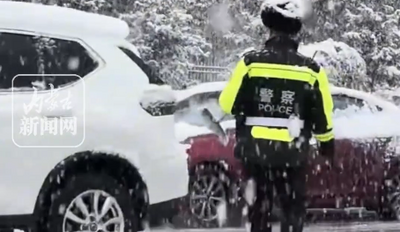 交警在大雪中給過往車輛掃雪